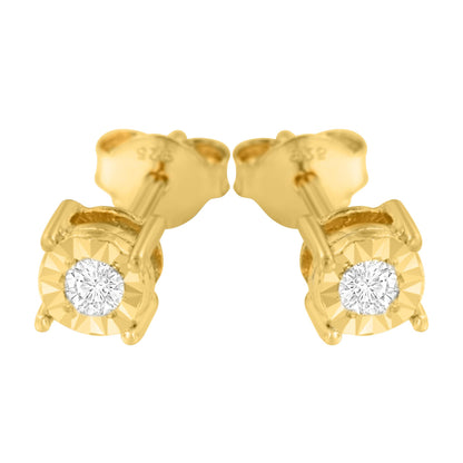 Close-up front angle of a pair of yellow metal stud earrings, each featuring a round white gemstone in mircale setting.