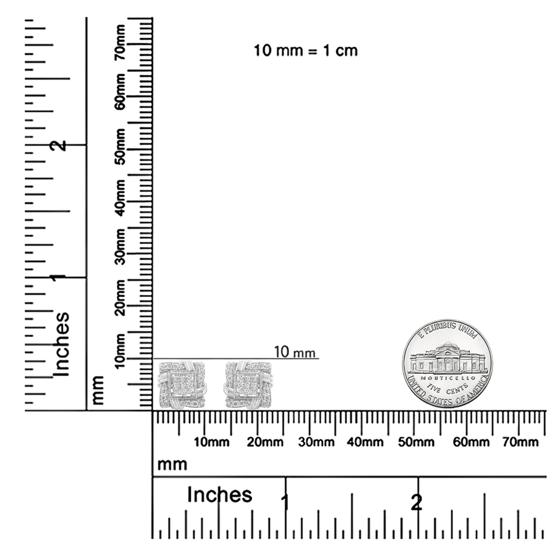 Pair of white metal earrings with round and princess shape white gemstones, shown from the front on a ruler and scale for size reference.