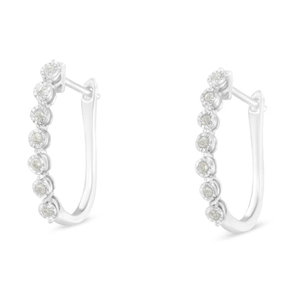 Pair of white metal hoop earrings with round white gemstones in a miracle setting, shown from a side angle.