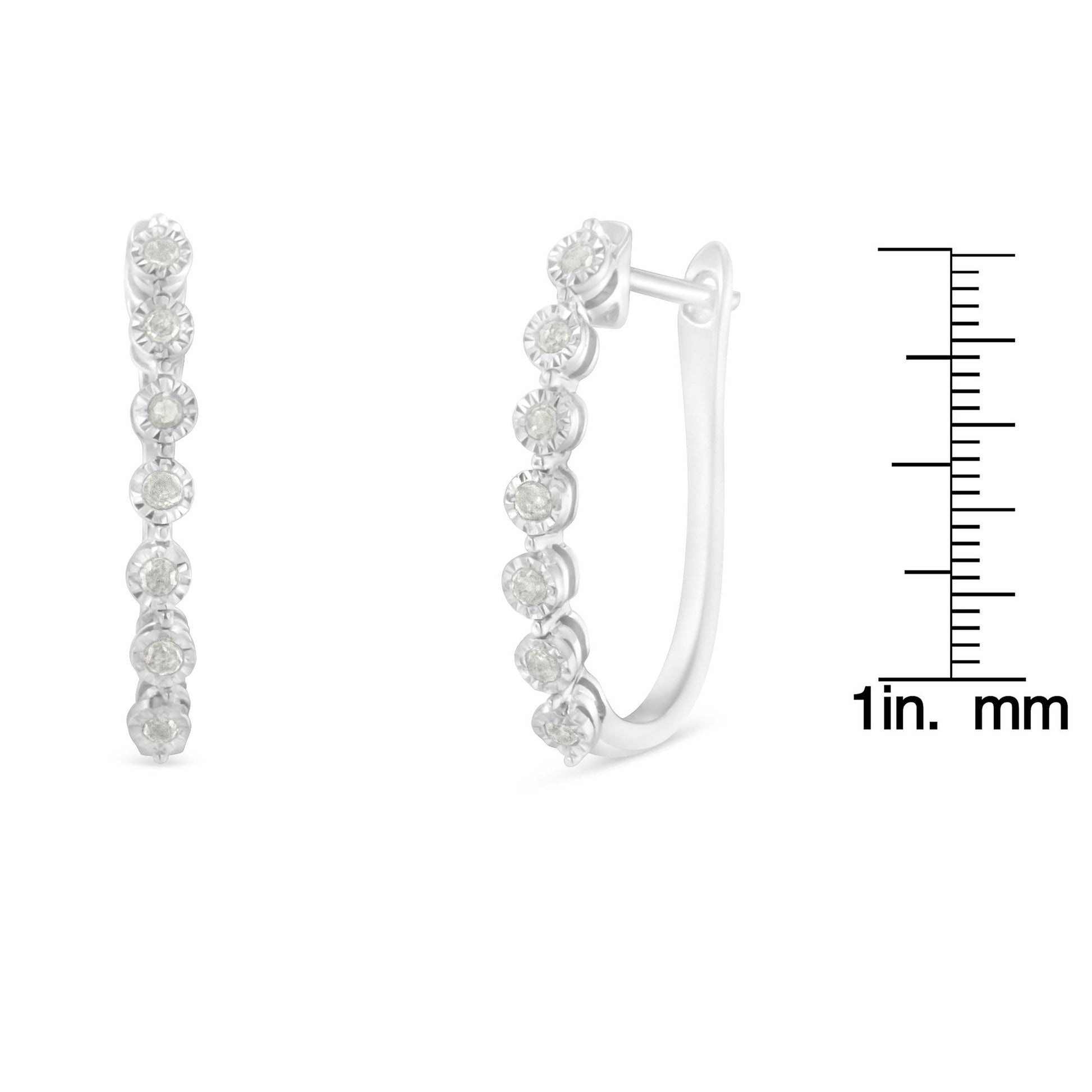 Front and side view of white metal hoop earrings with round white gemstones in miracle setting, shown next to a ruler for size reference.