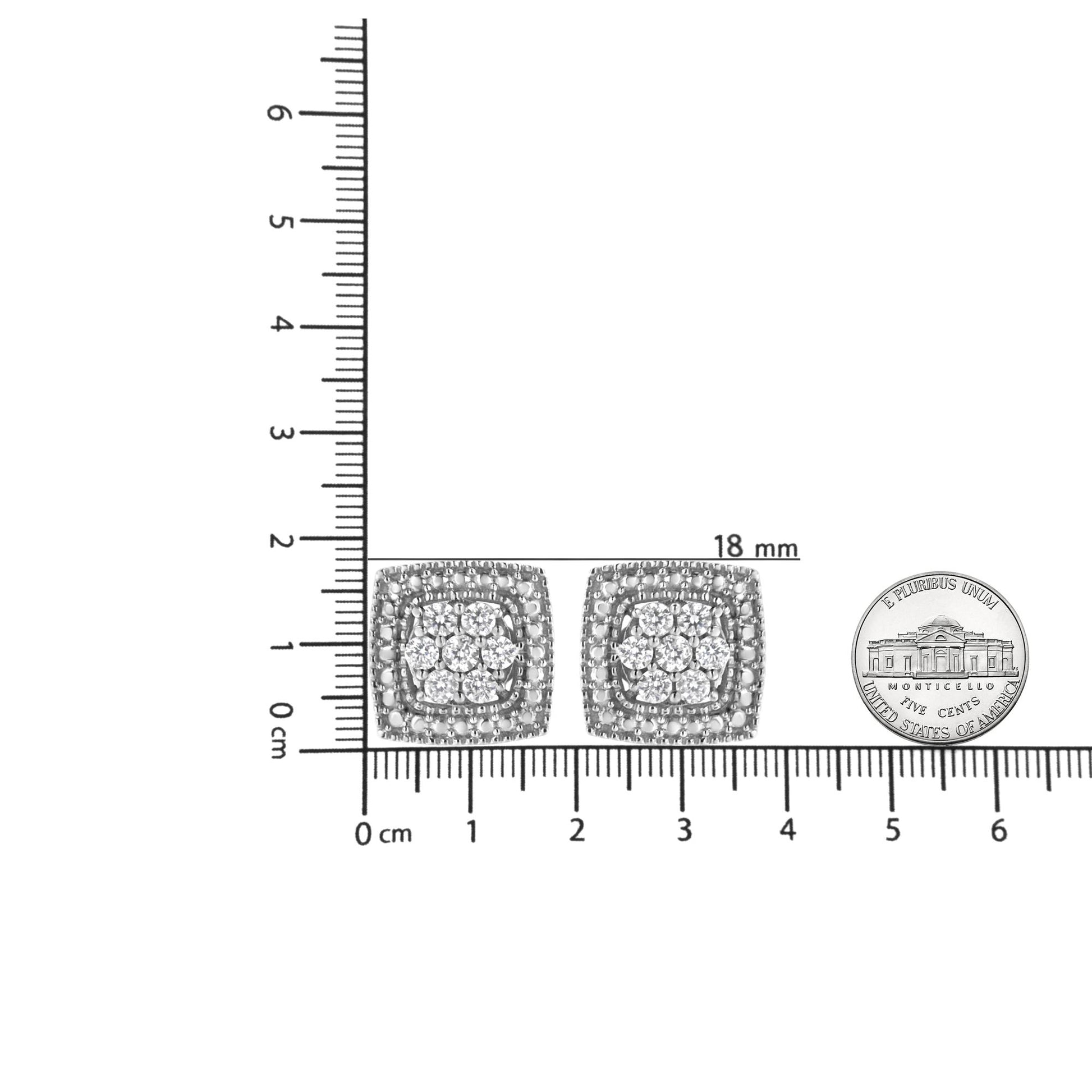 Pair of white metal square-shaped earrings with round white gemstones in prong settings, shown from front on a ruler for size reference.