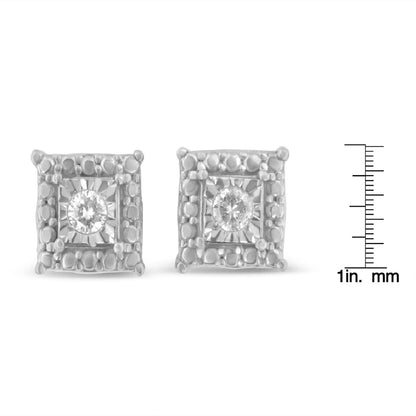 Front view of white metal square-shaped earrings with a round white gemstone in a miracle setting, shown next to a ruler for size reference.