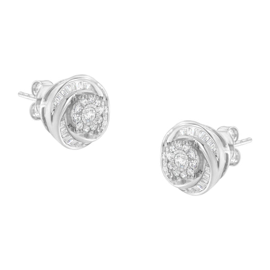 Front angled view of a pair of white metal stud earrings featuring a swirl design with round and baguette-shaped white gemstones in prong, miracle, and channel settings.