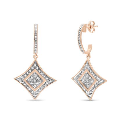 Front angle view of a pair of rose metal earrings featuring diamond-shaped drop pendants with pave-set white round gemstones and hoop posts also adorned with white round gemstones.