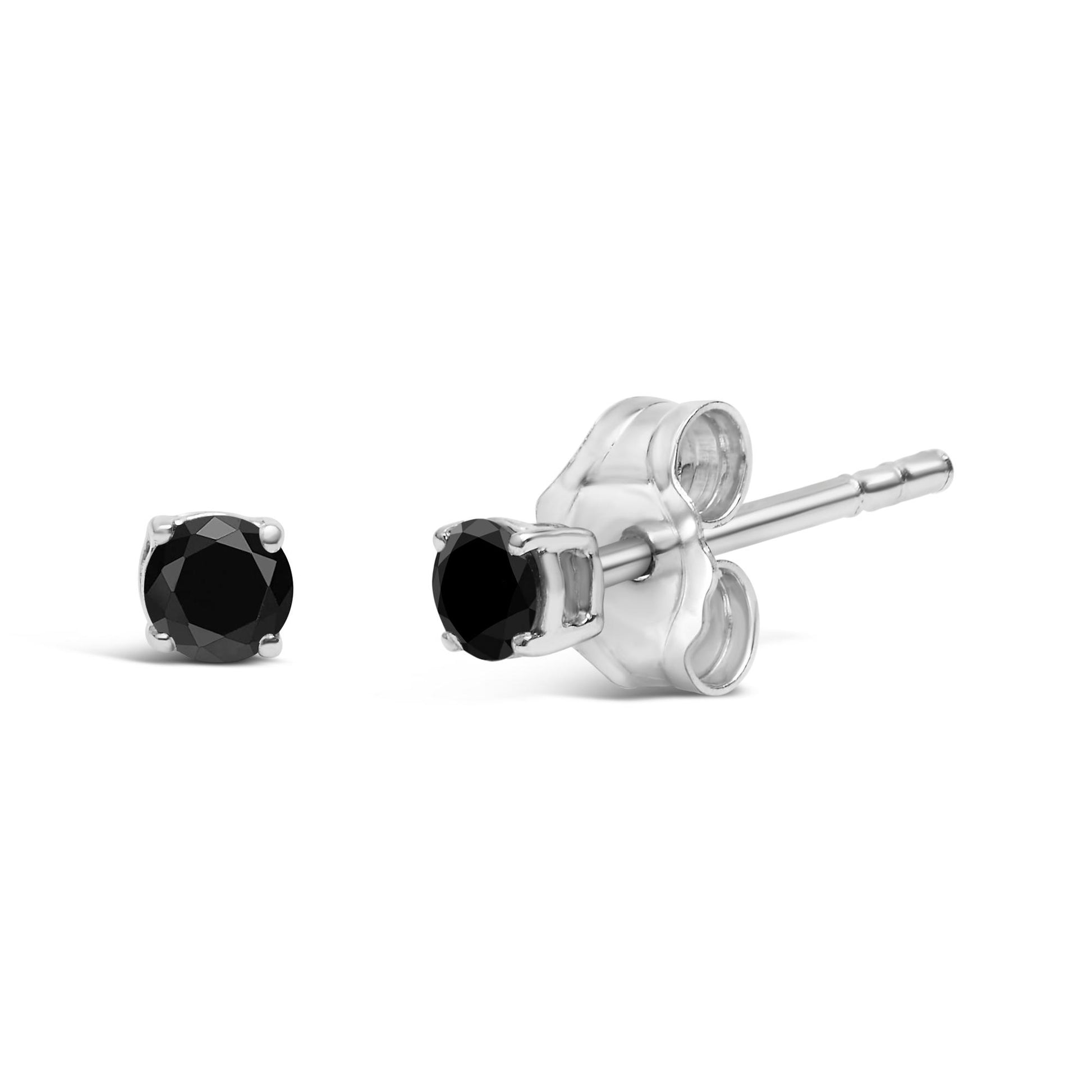 Close-up side angle of a pair of white metal stud earrings, each set with a round black gemstone in prong settings.