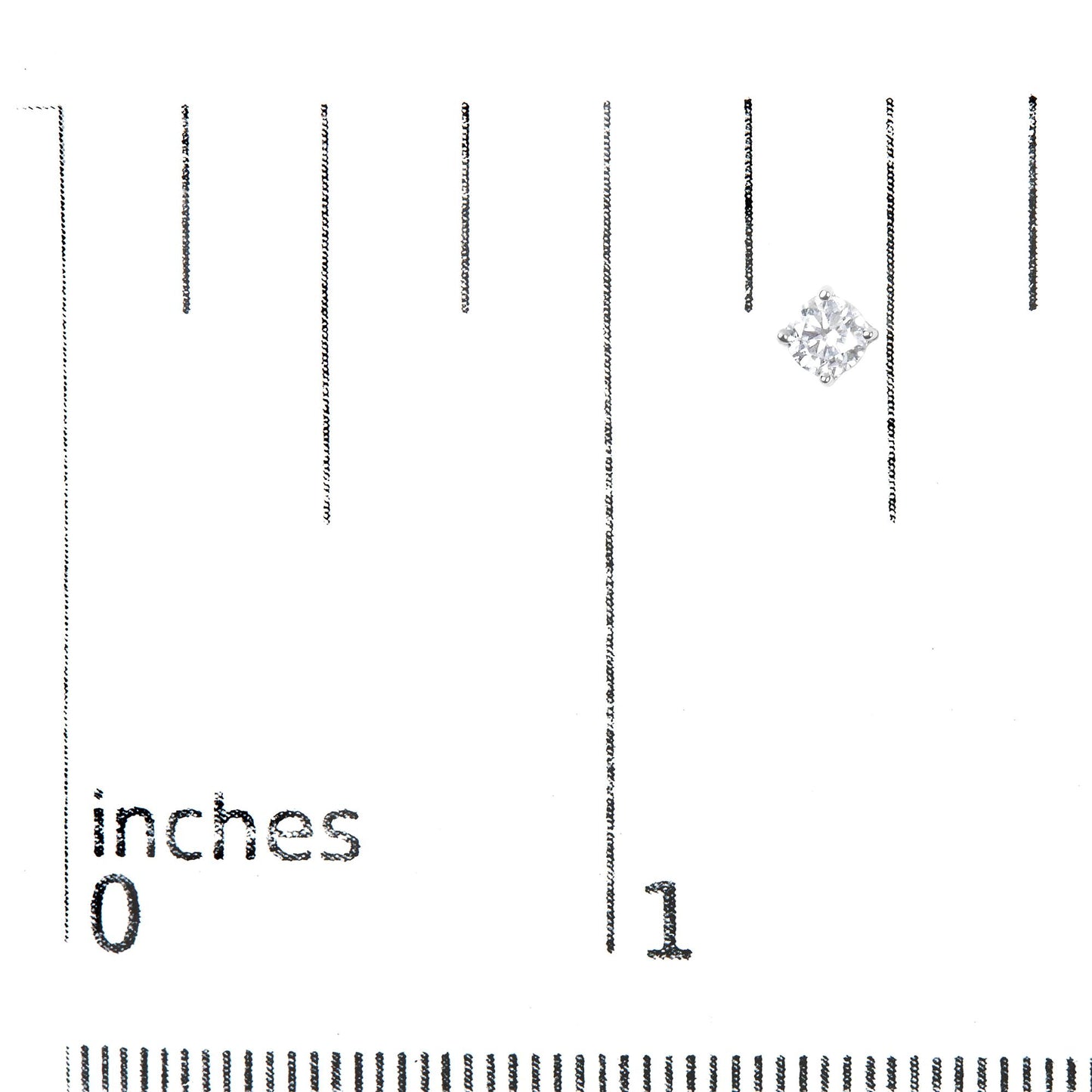 Close-up front angle of a white metal stud earring with a round white gemstone in a four-prong setting placed on a ruler for size reference.
