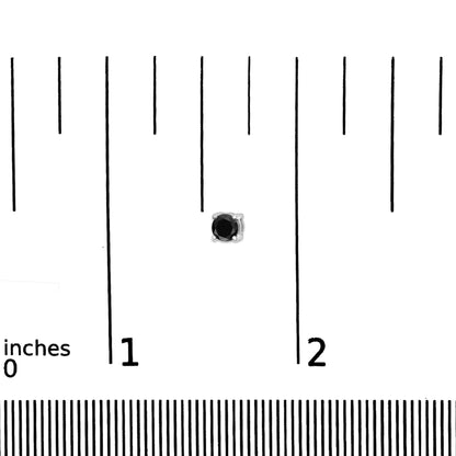 Close-up front view of a white metal stud earring with a round black gemstone in a 4-prong setting placed on a ruler for size reference.