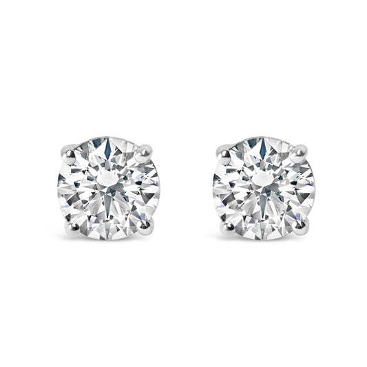 Close-up front view of a pair of white metal stud earrings with round white gemstones in four-prong settings.
