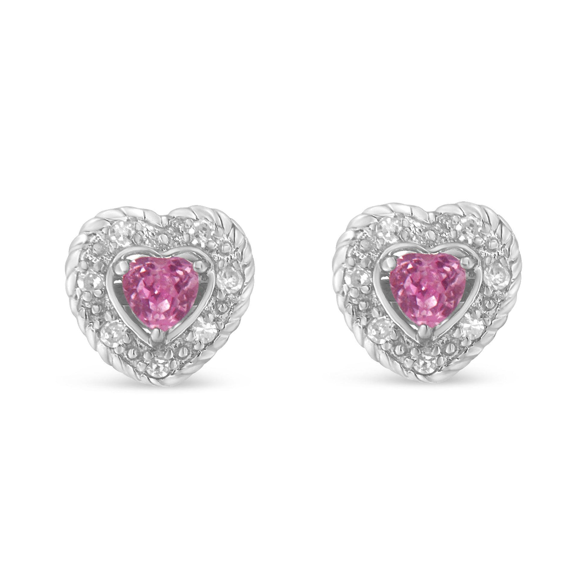 Front view of white heart-shaped earrings with a central pink heart-shaped gemstone surrounded by white round pave-set gemstones.
