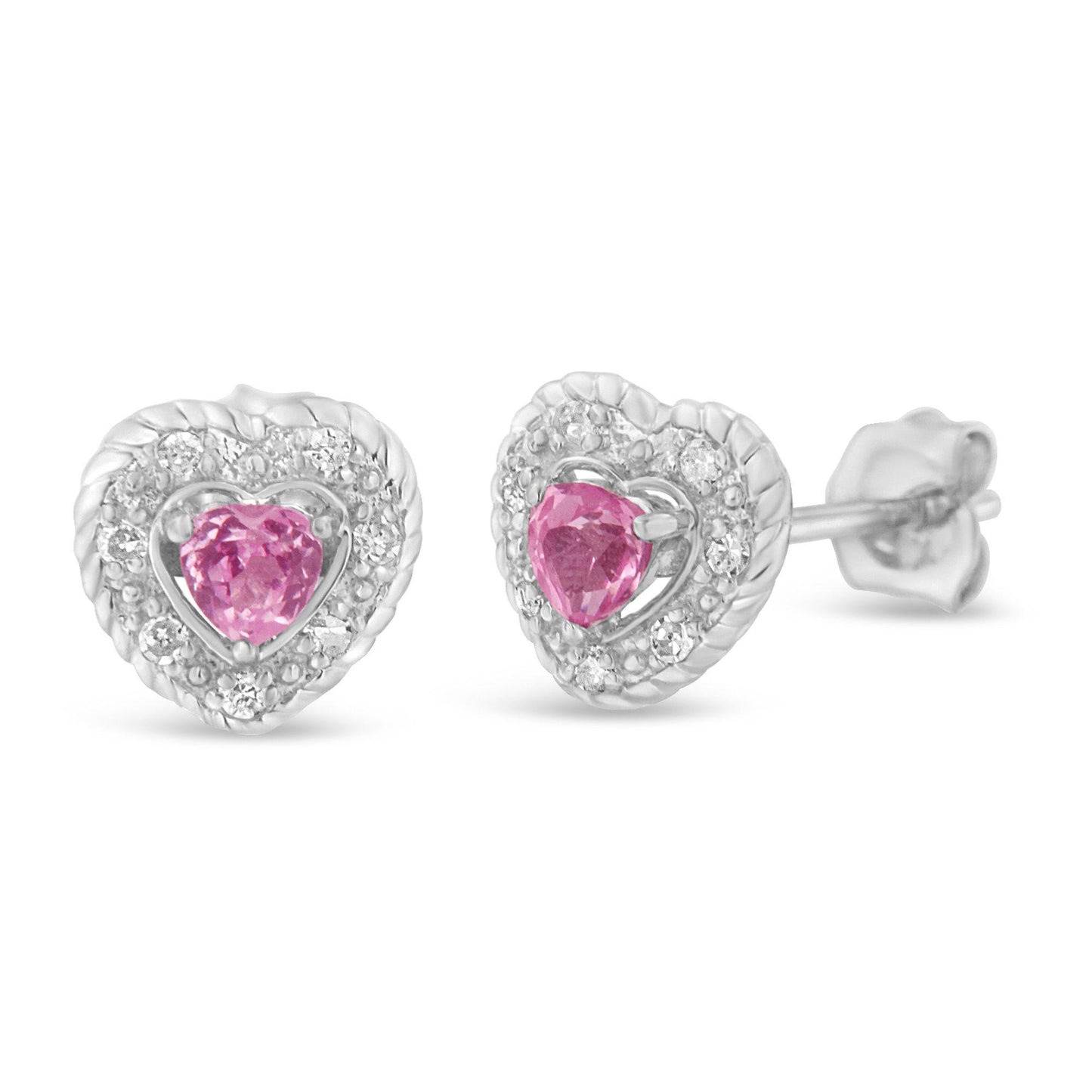 Close-up front angled view of white heart-shaped earrings with pink heart-shaped gemstones in the center surrounded by small round white gemstones in pave setting.