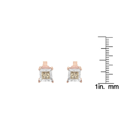 Front view of white and rose colored metal earrings with square brownish gemstones, shown next to a ruler for size reference.