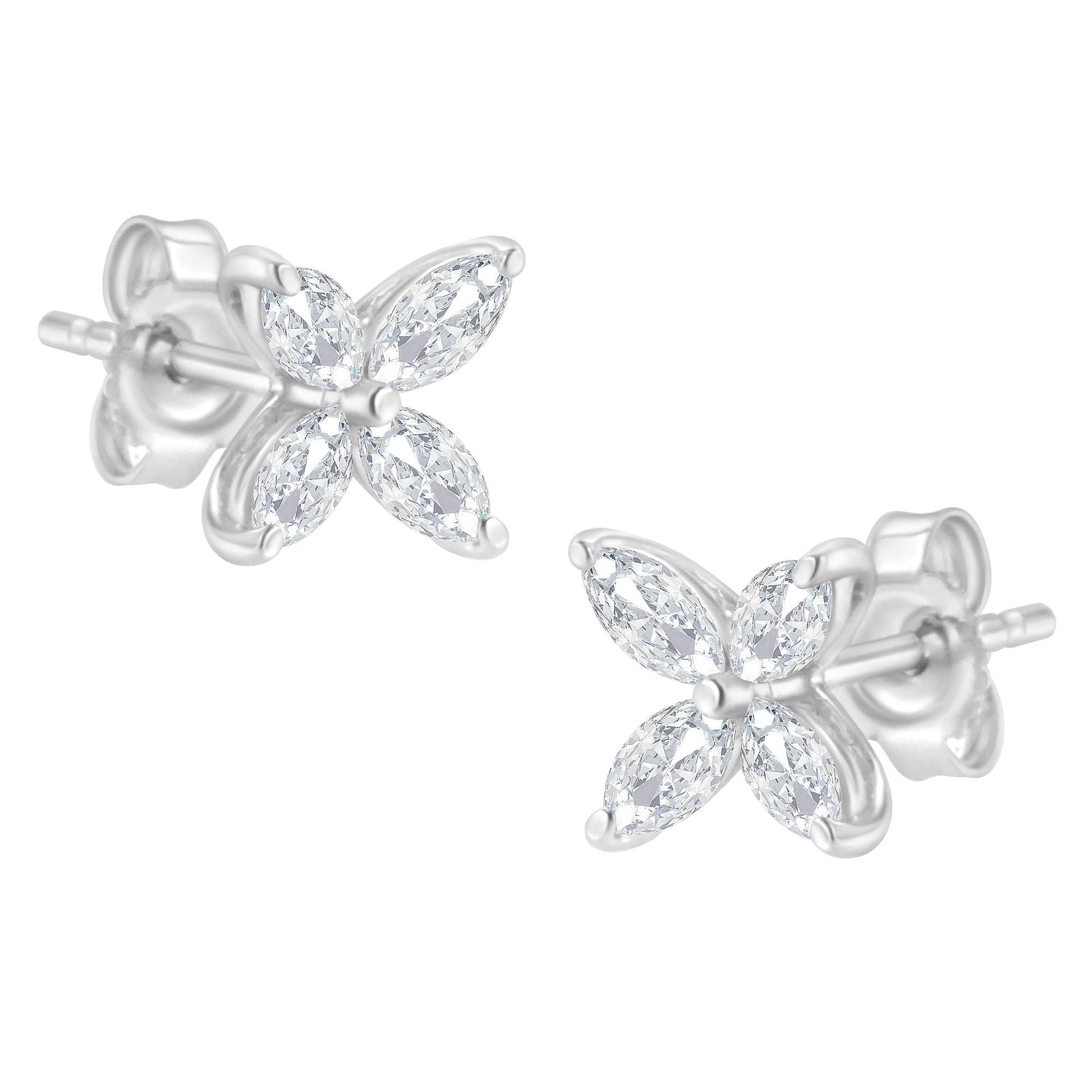 Close-up view of white metal stud earrings with four marquise-shaped white gemstones arranged in a flower pattern, shown from a slightly angled perspective.