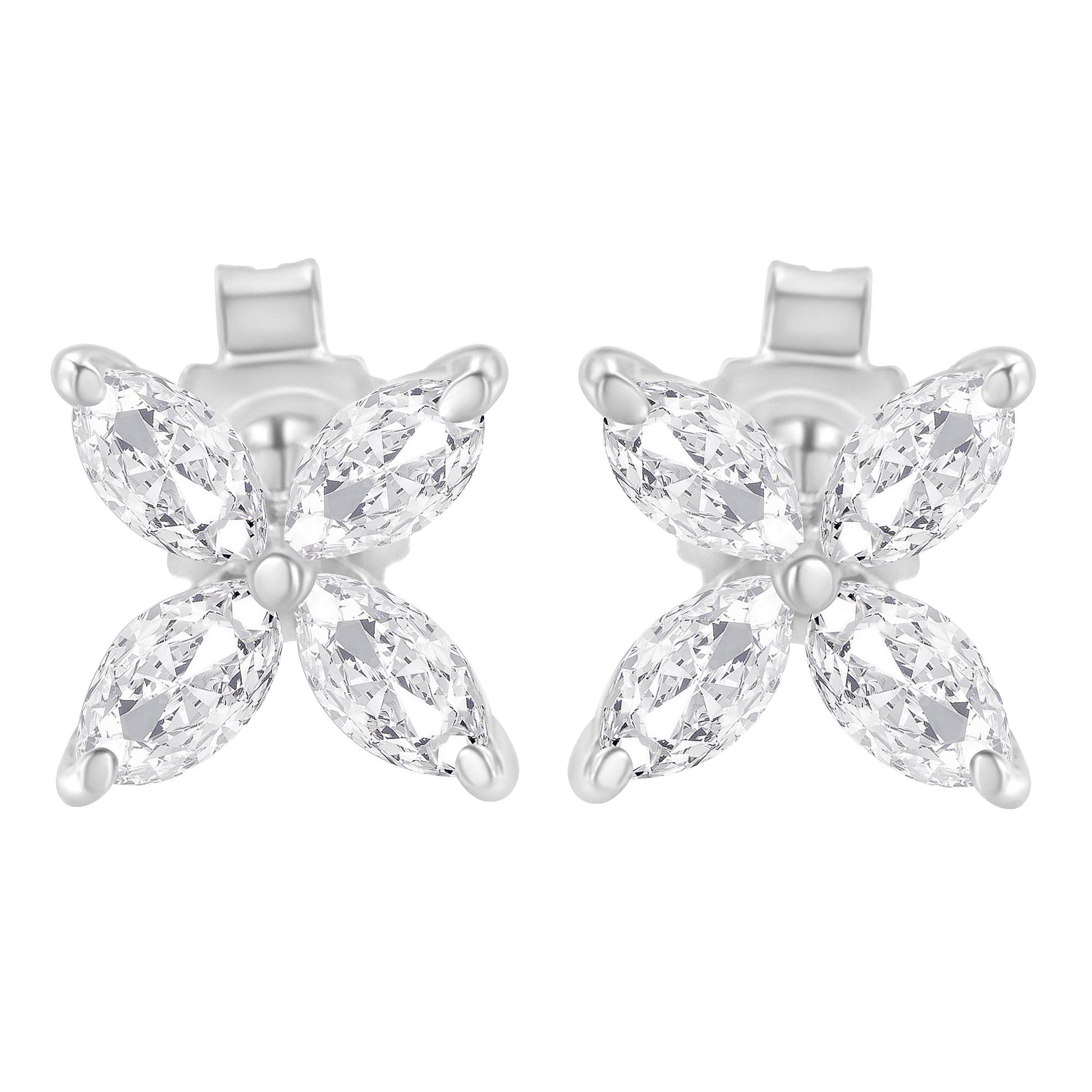 Close-up front view of a pair of white metal earrings, each featuring four marquise-shaped white gemstones arranged in a floral pattern with prong settings.