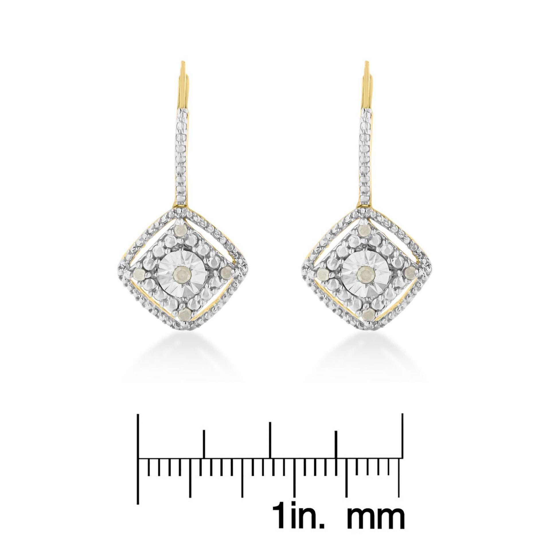 Pair of yellow metal earrings with white round prong-set gemstones arranged in a square design, shown from the front on a ruler for size reference.
