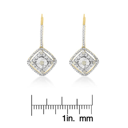 Pair of yellow metal earrings with white round prong-set gemstones arranged in a square design, shown from the front on a ruler for size reference.