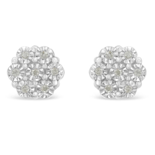 Front-angle view of a pair of white metal earrings shaped like flowers with multiple round white gemstones arranged in a miracle setting.