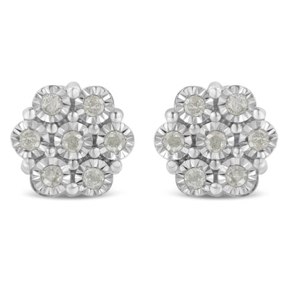 Front angle view of white metal earrings with round white gemstones arranged in a floral cluster design.