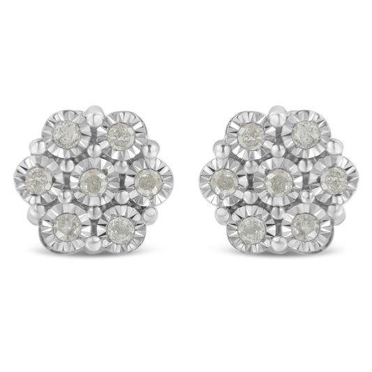 Front angle view of white metal earrings with round white gemstones arranged in a floral cluster design.