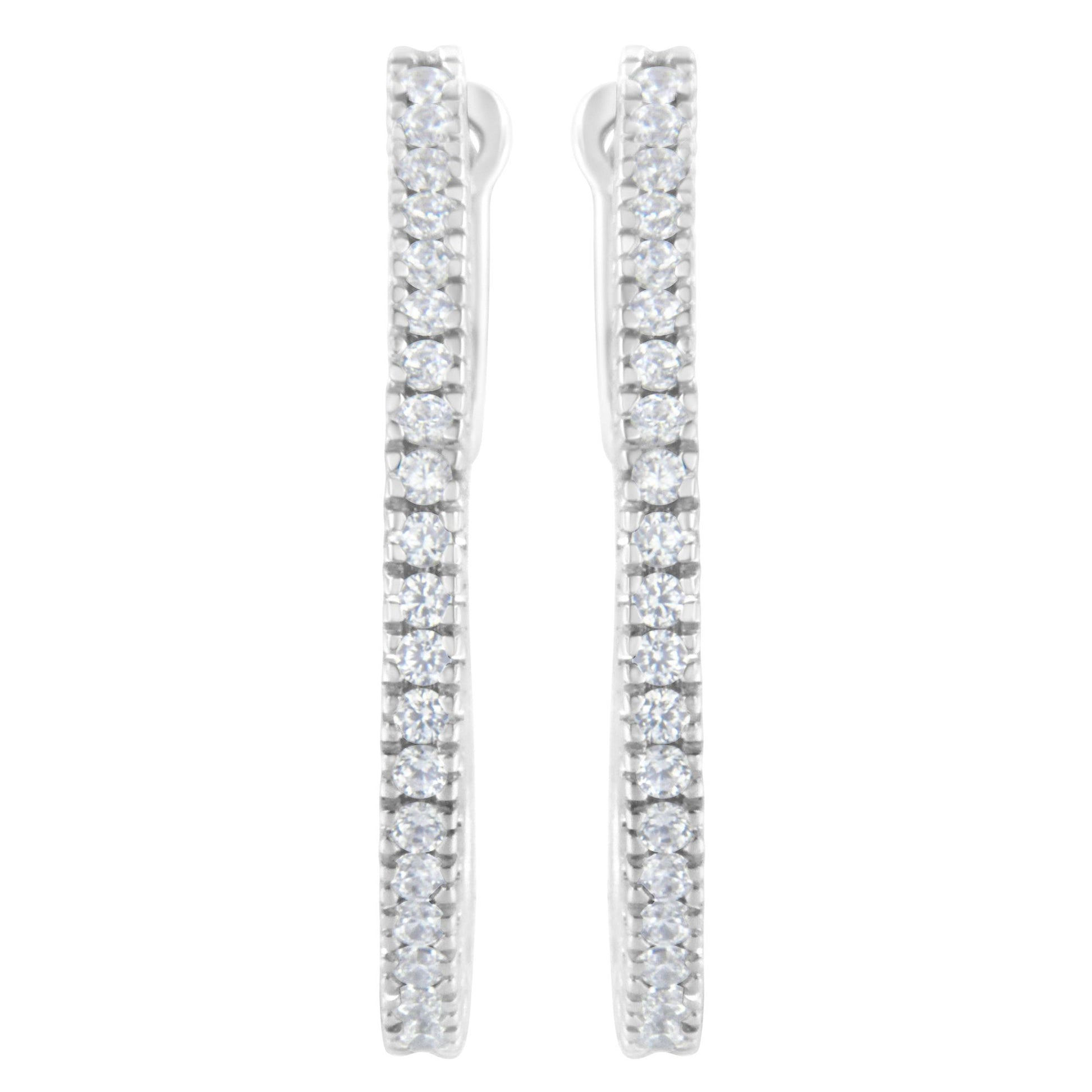 Front view of white metal earrings with vertical rows of round white gemstones in prong settings.