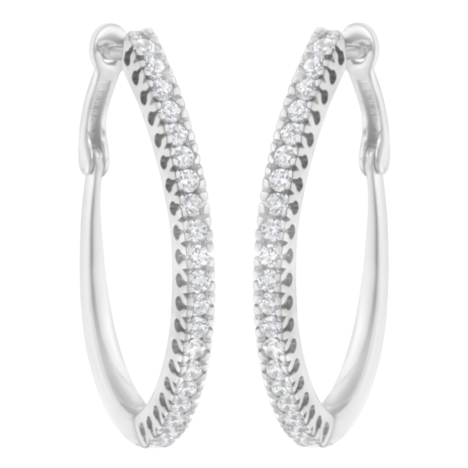Front-facing close-up of white metal hoop earrings with rows of round white gemstones in prong settings along the outer edges.