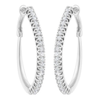 Front-facing close-up of white metal hoop earrings with rows of round white gemstones in prong settings along the outer edges.