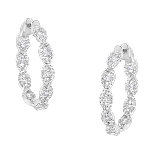 Front angle view of white metal hoop earrings with an intertwined twisted design, each encrusted with numerous small white gemstones in prong settings.