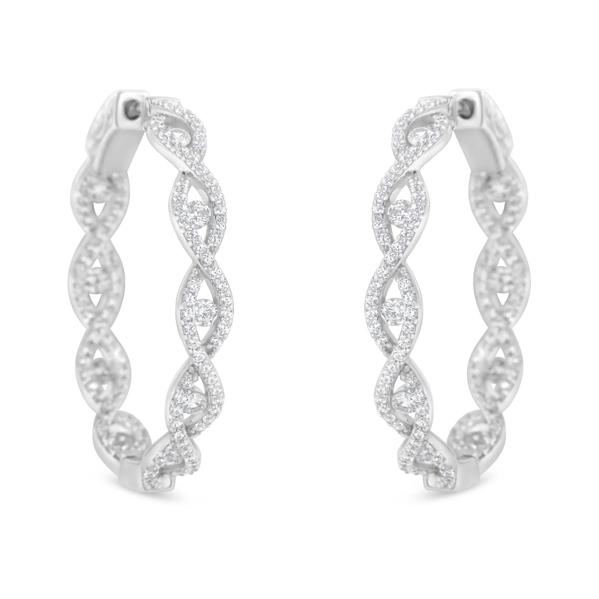 Front-facing close-up of white metal hoop earrings with intertwined design, adorned with multiple round white gemstones in prong settings.