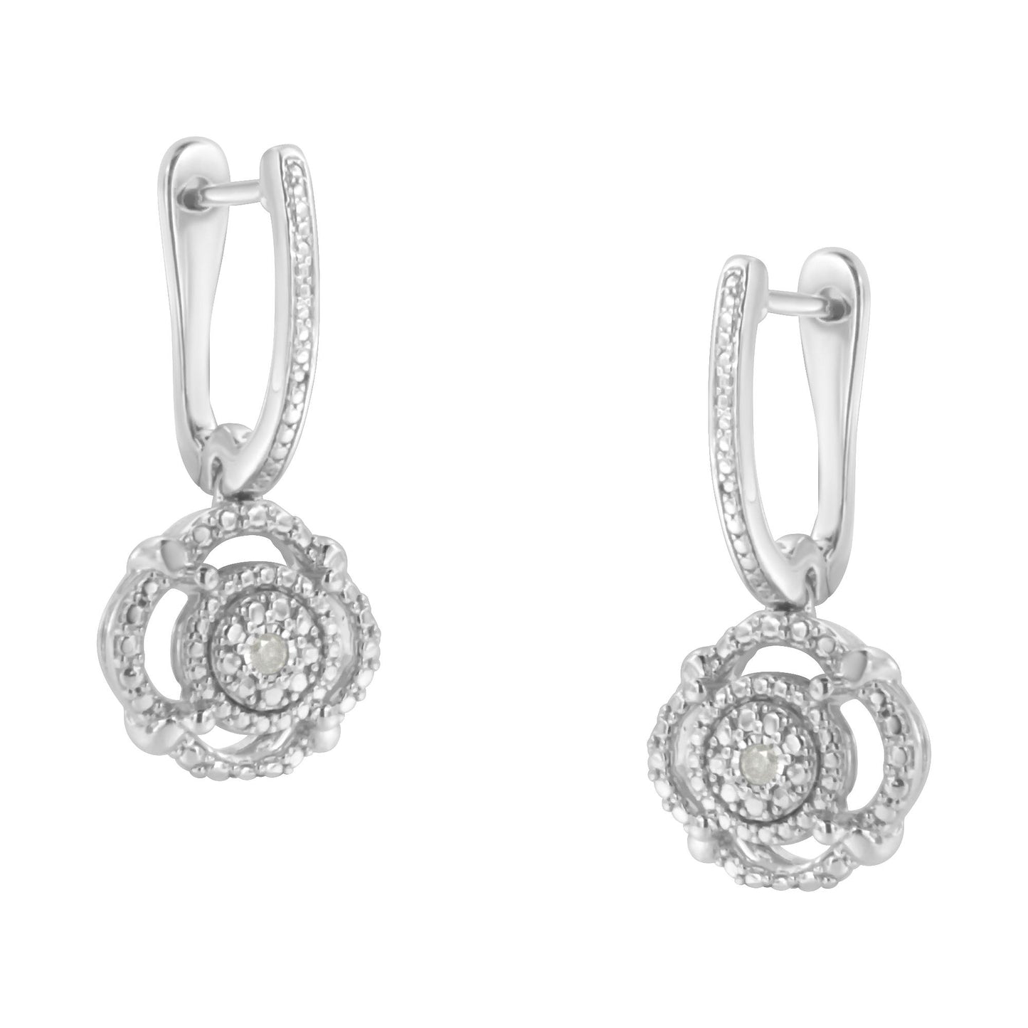 Front angle of white metal dangle earrings with round white gemstones set in intricate circular design and encrusted hoops.