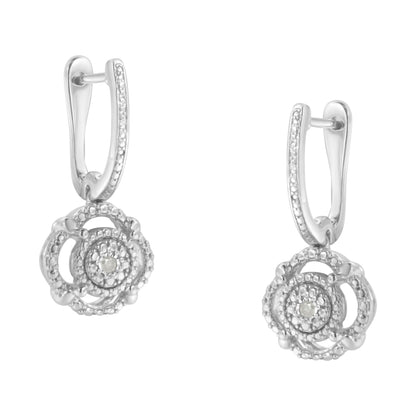 Front angle of white metal dangle earrings with round white gemstones set in intricate circular design and encrusted hoops.