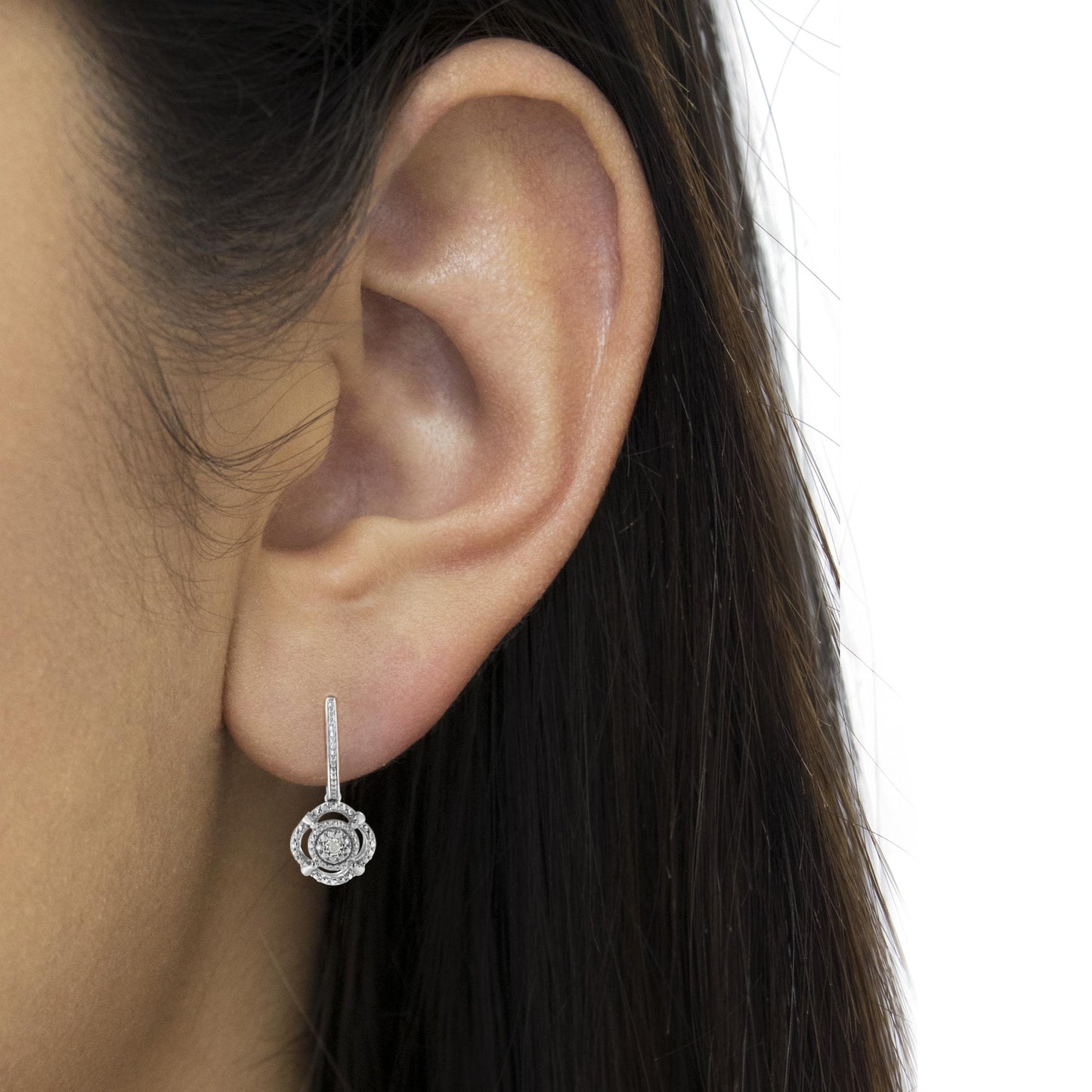 Close-up side view of a white metal earring with a round white gemstone in a miracle setting, worn on a model.