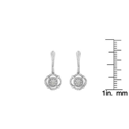 Front view of white metal dangle earrings with round white gemstones, shown next to a ruler for size reference.