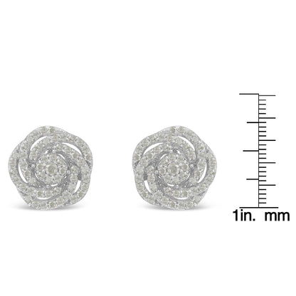 Pair of white metal round cluster earrings with multiple white gemstones in a swirling design, shown from the front on a ruler for size reference.