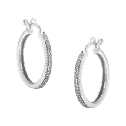 Pair of white metal hoop earrings with round white gemstones in pave setting along the outer edge, shown at a slight angle.