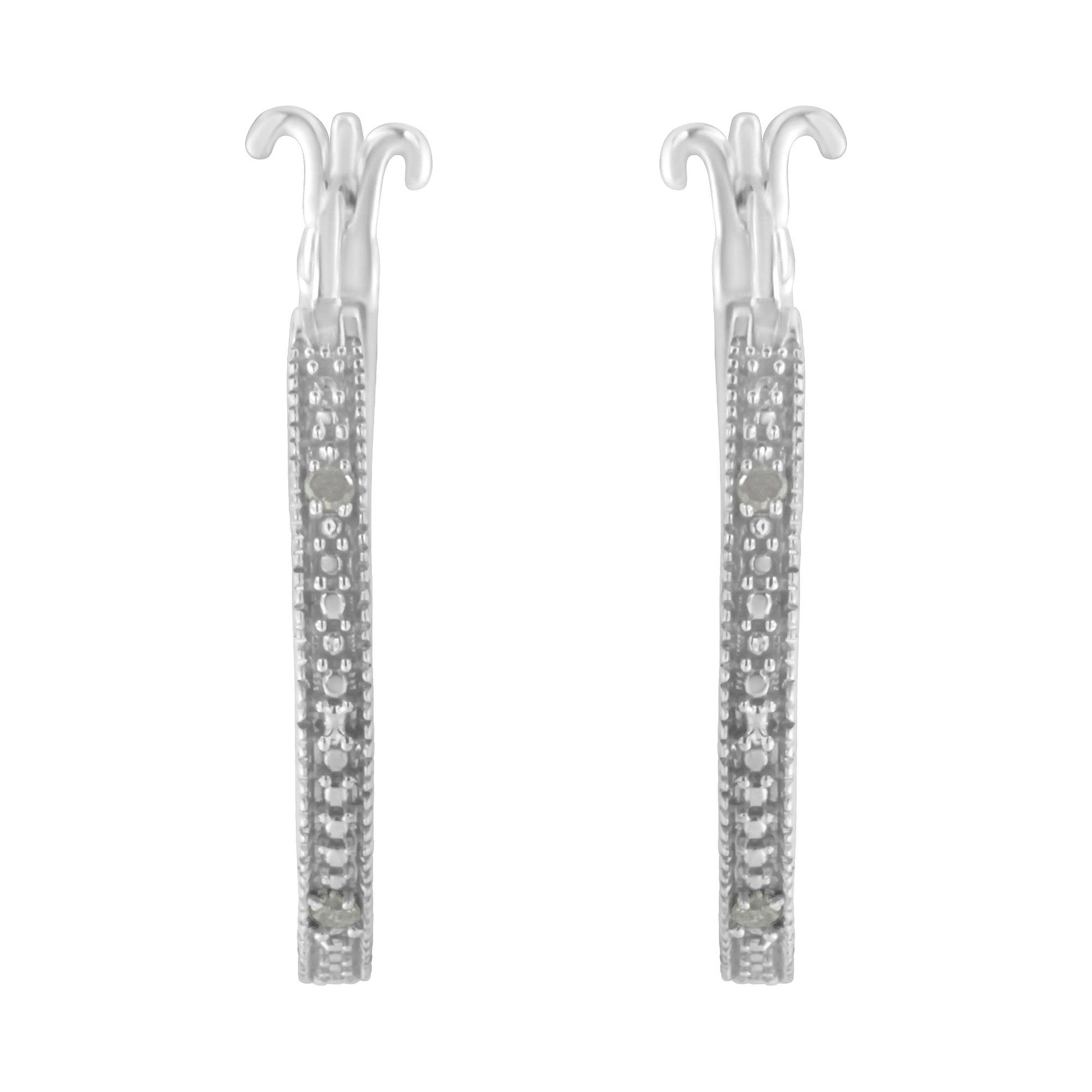 Front-facing shot of a pair of white metal earrings with pave-set round white gemstones along the visible front edges.