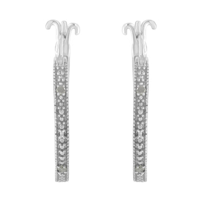 Front-facing shot of a pair of white metal earrings with pave-set round white gemstones along the visible front edges.