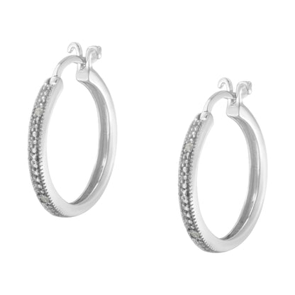 Pair of white metal hoop earrings with round white gemstones in pave setting, shown in a front angle view.
