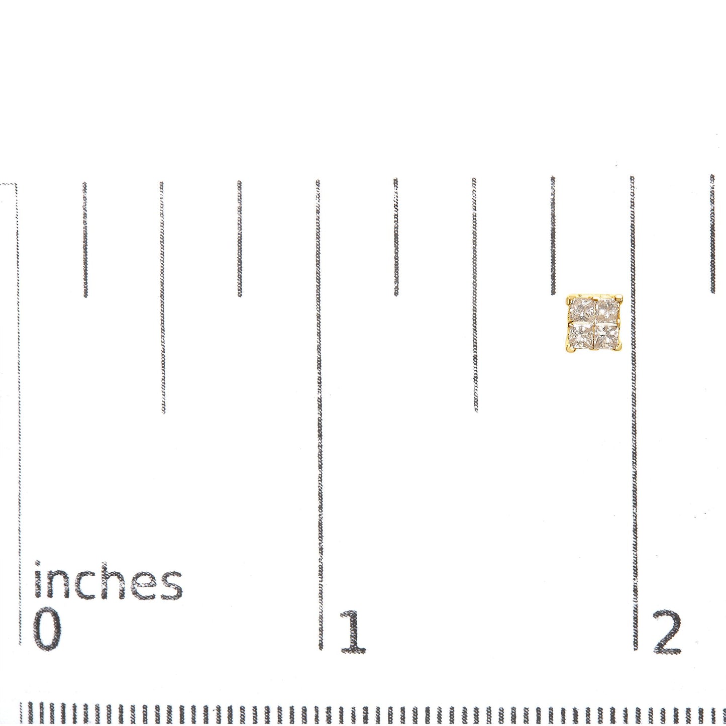 Close-up of a yellow metal square-shaped earring with four princess-cut white gemstones in an invisible setting, placed on a ruler for size reference.
