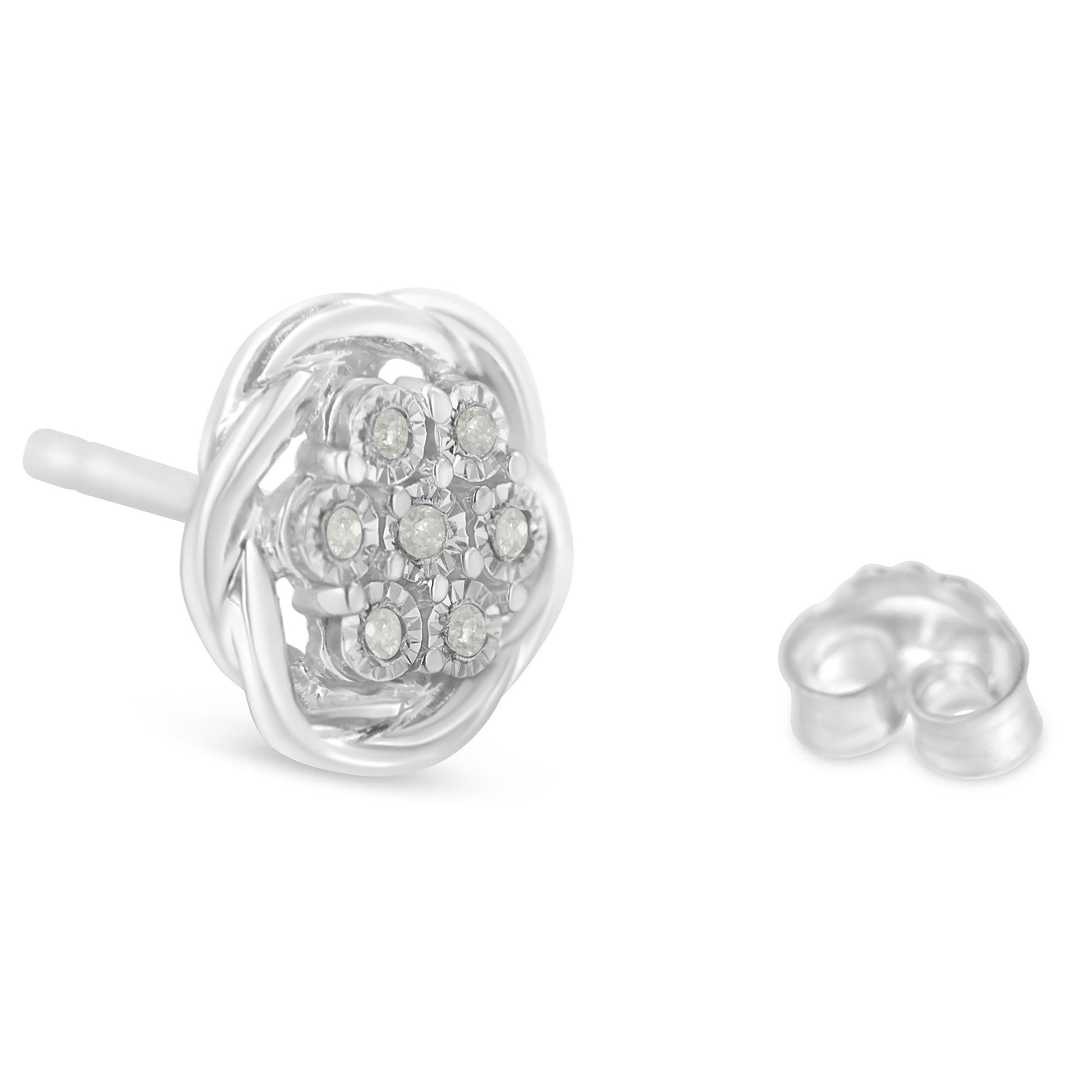 Close-up front angled view of white metal stud earrings with round white gemstones in a clustered miracle setting, with one earring back shown.