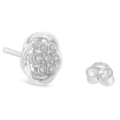 Close-up front angled view of white metal stud earrings with round white gemstones in a clustered miracle setting, with one earring back shown.