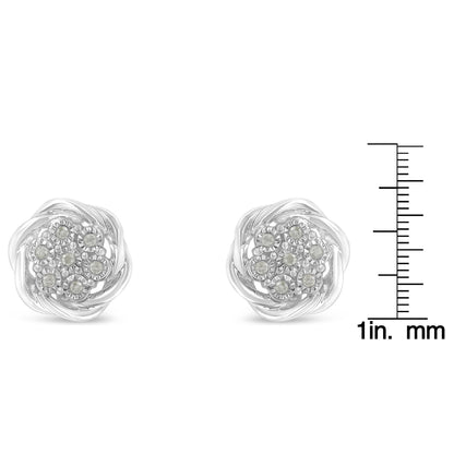 Pair of white metal round cluster earrings with white gemstones in miracle setting, shown front view, placed next to a ruler for size reference.