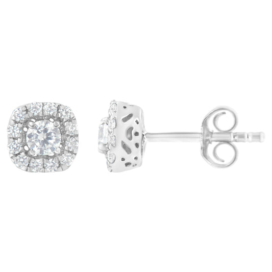 Front and side views of a pair of white metal earrings with a central round white gemstone in a 4-prong setting, surrounded by a halo of smaller round white gemstones in a pave setting.