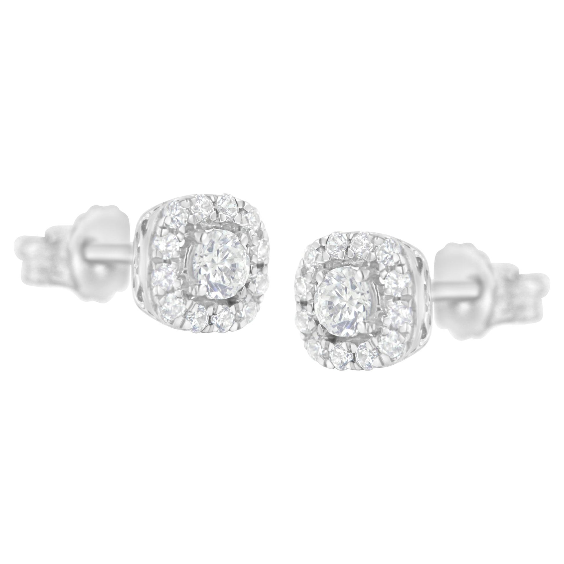 Pair of white metal stud earrings with round white gemstones in four-prong and pave settings, shown from a front angle.