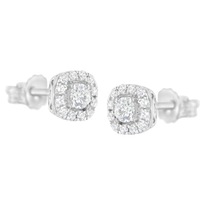 Pair of white metal stud earrings with round white gemstones in four-prong and pave settings, shown from a front angle.