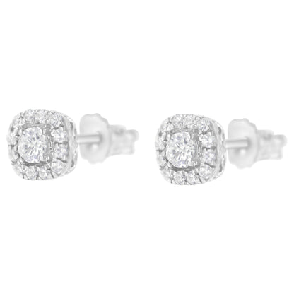 Front angled view of white metal stud earrings with a central round white gemstone in a four-prong setting surrounded by smaller round white gemstones in pave setting.