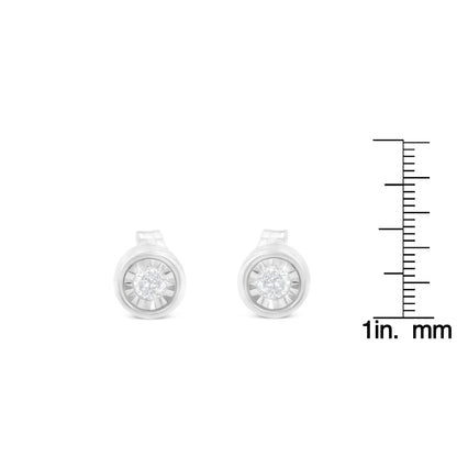 Front view of white metal round shaped stud earrings with white gemstones, shown beside a ruler for size reference.