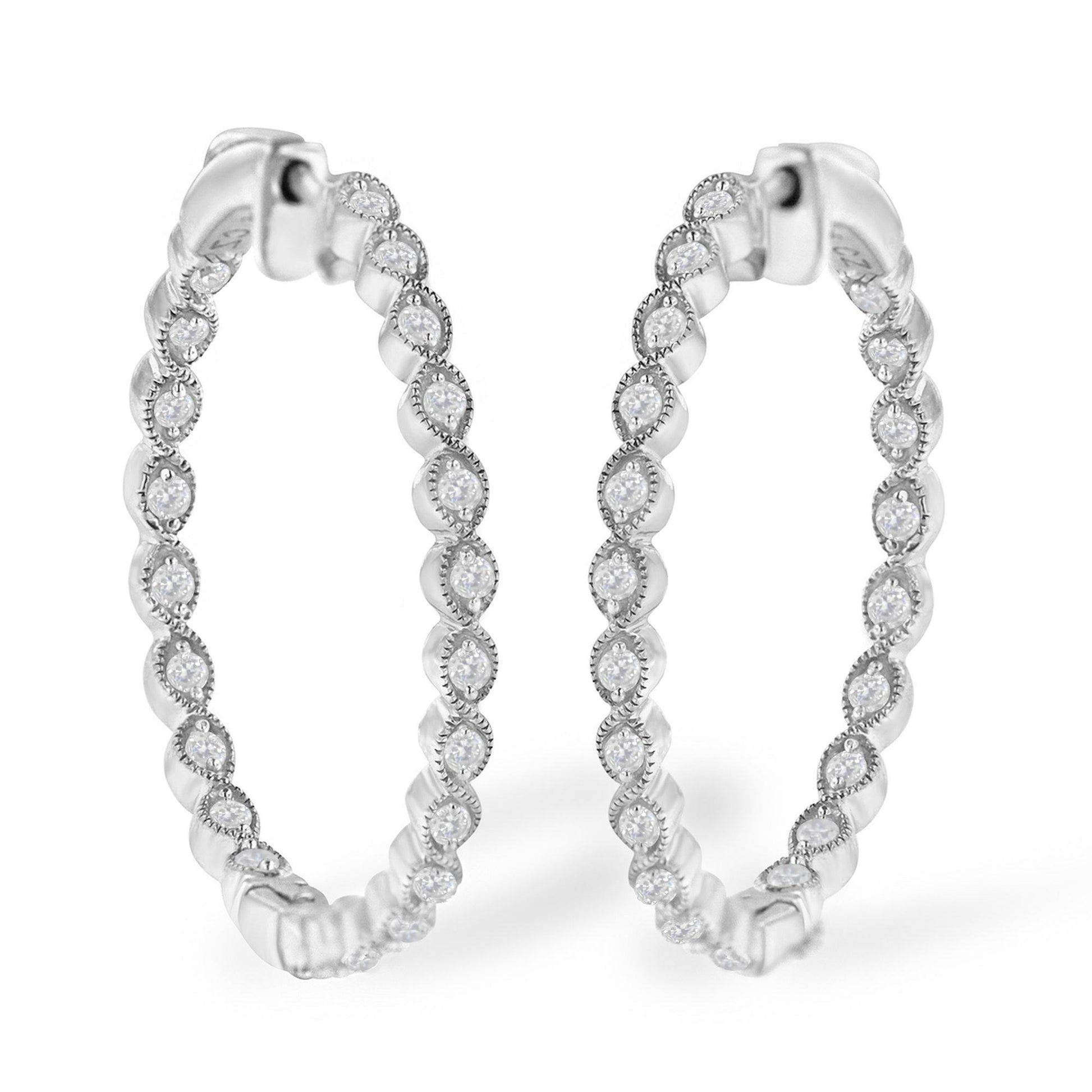 Pair of white metal hoop earrings adorned with round white gemstones in prong settings, shown from a front angled view.