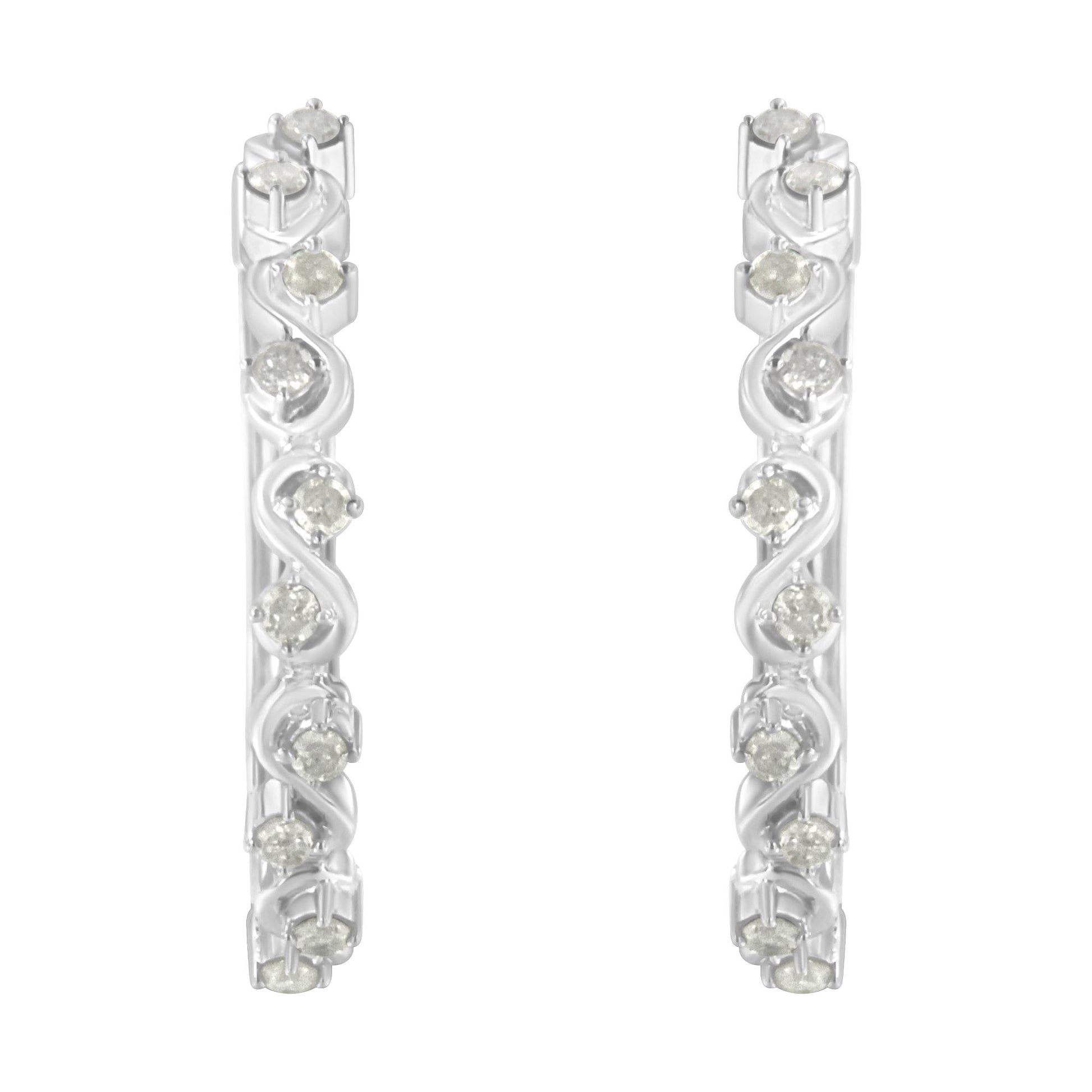 Front-facing close-up of white metal hoop earrings featuring round white gemstones in prong settings arranged in a swirl pattern.