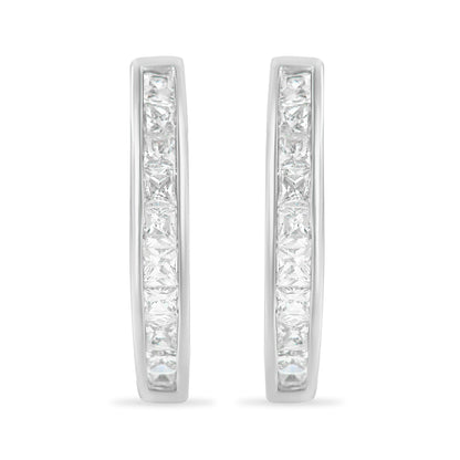 Front-facing view of white metal hoop earrings set with two rows of princess-shaped white channel-set gemstones.