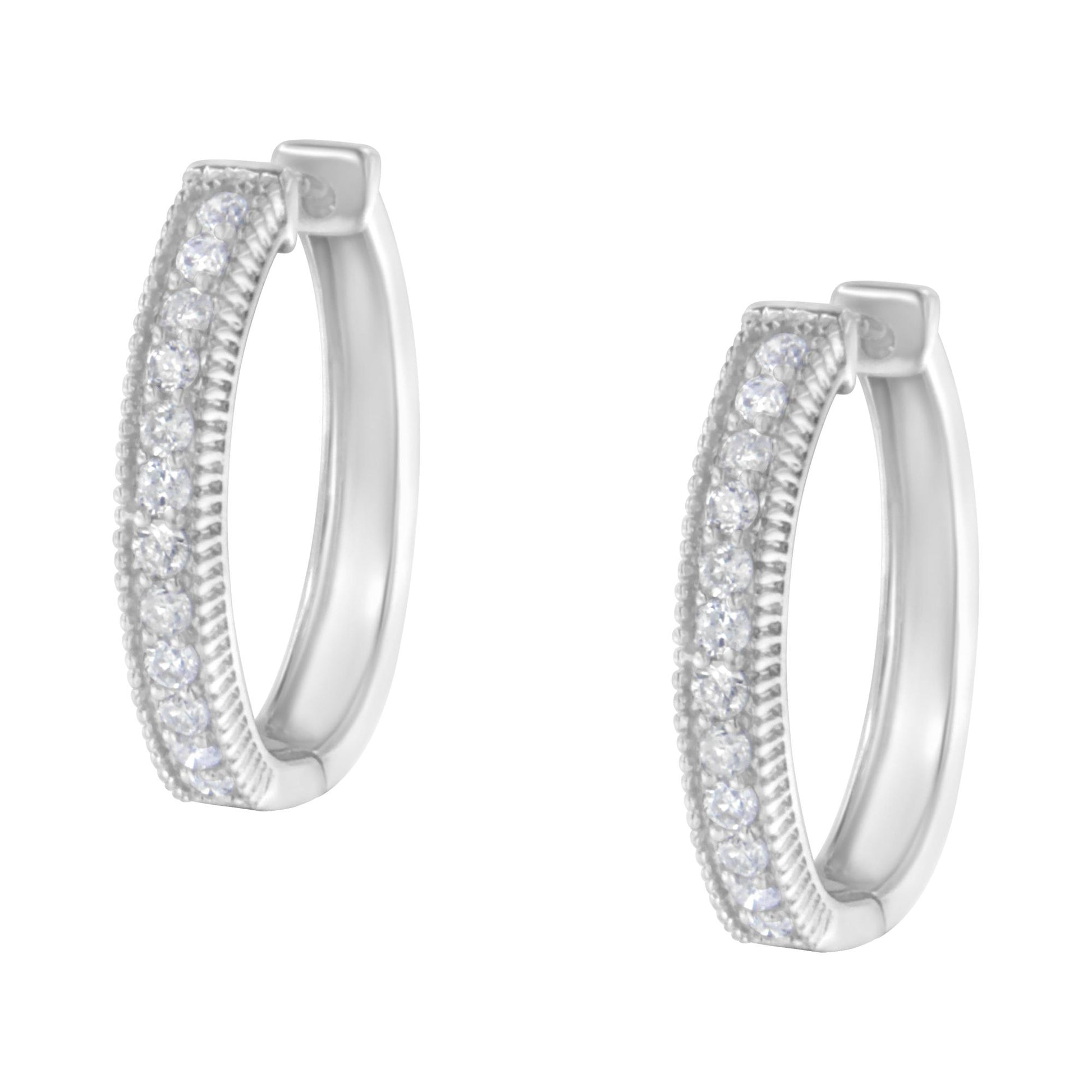 Pair of white metal hoop earrings set with round white gemstones in prong setting, shown in a front angle.