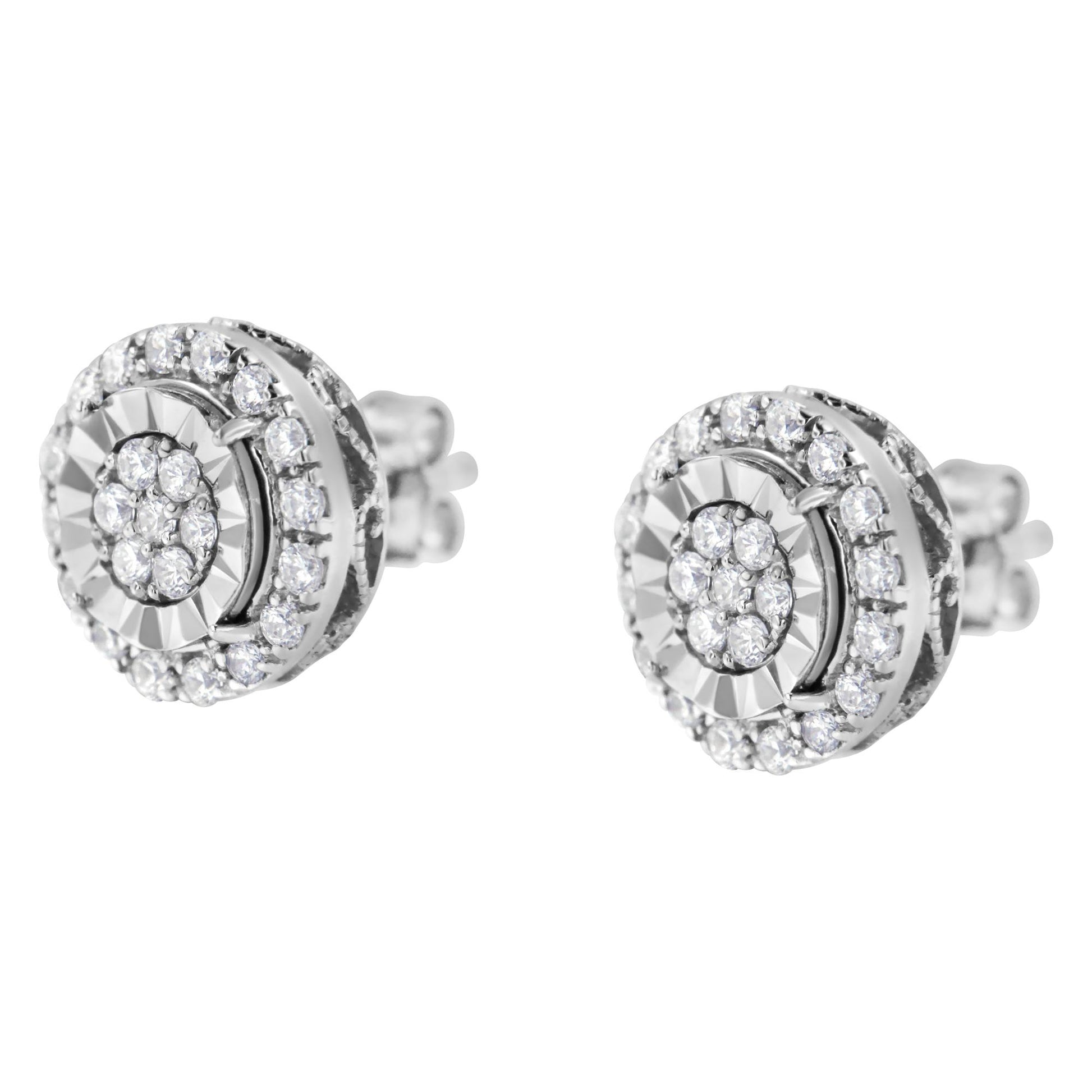 Pair of white metal stud earrings with round white gemstones in prong settings, shown at a slight angle.